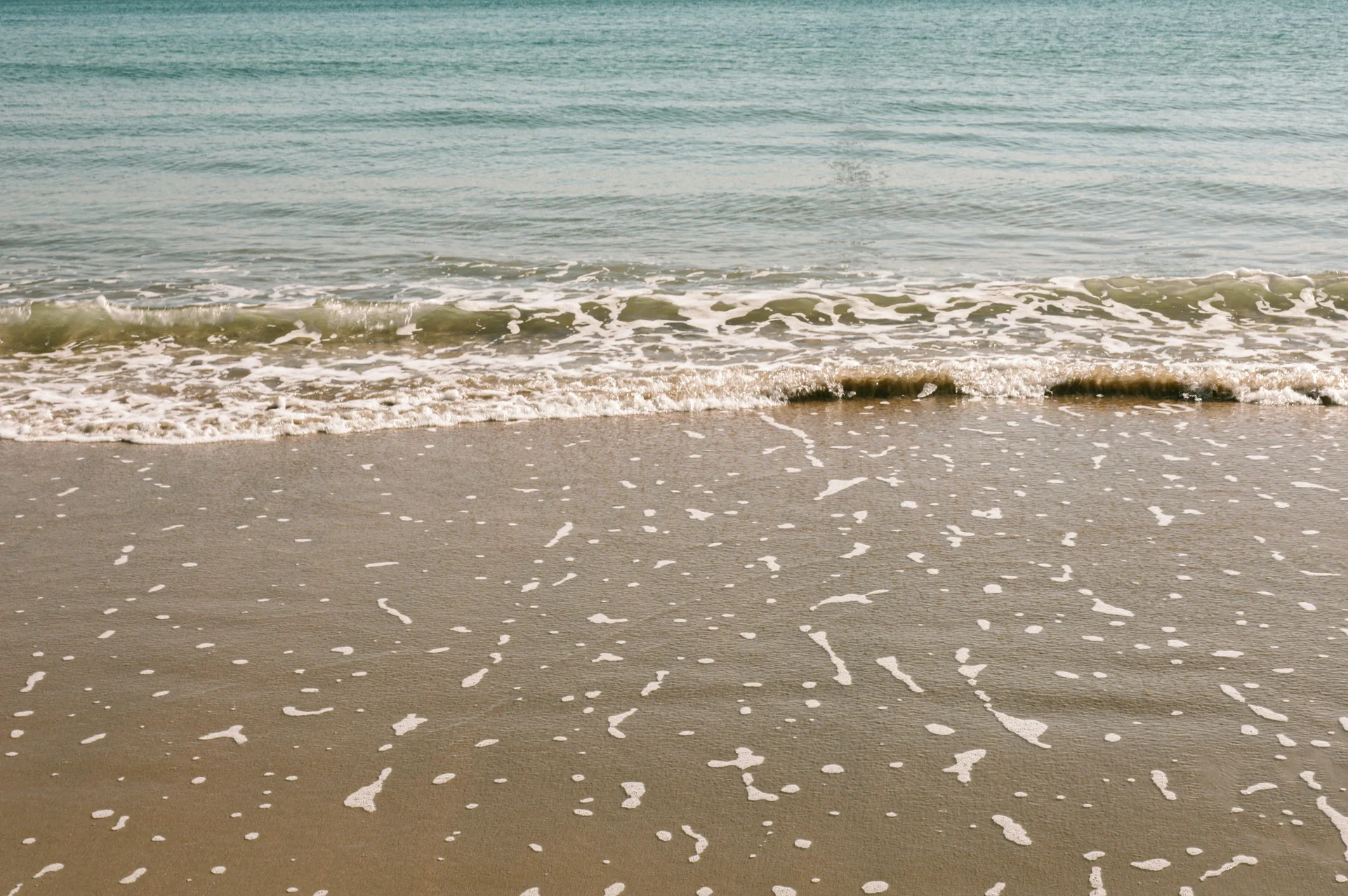 Sandy beach with ocean waves rolling in at Haeundae, Busan