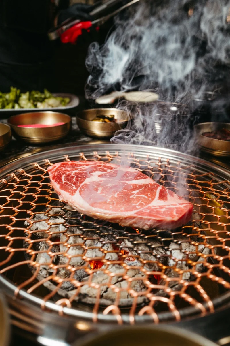 Korean BBQ meat sizzling on a grill at a Seomyeon restaurant in Busan