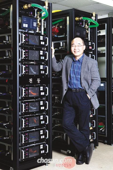 서울대 이재진 교수가 슈퍼컴퓨터 천둥 옆에서 포즈를 취하고 있다.