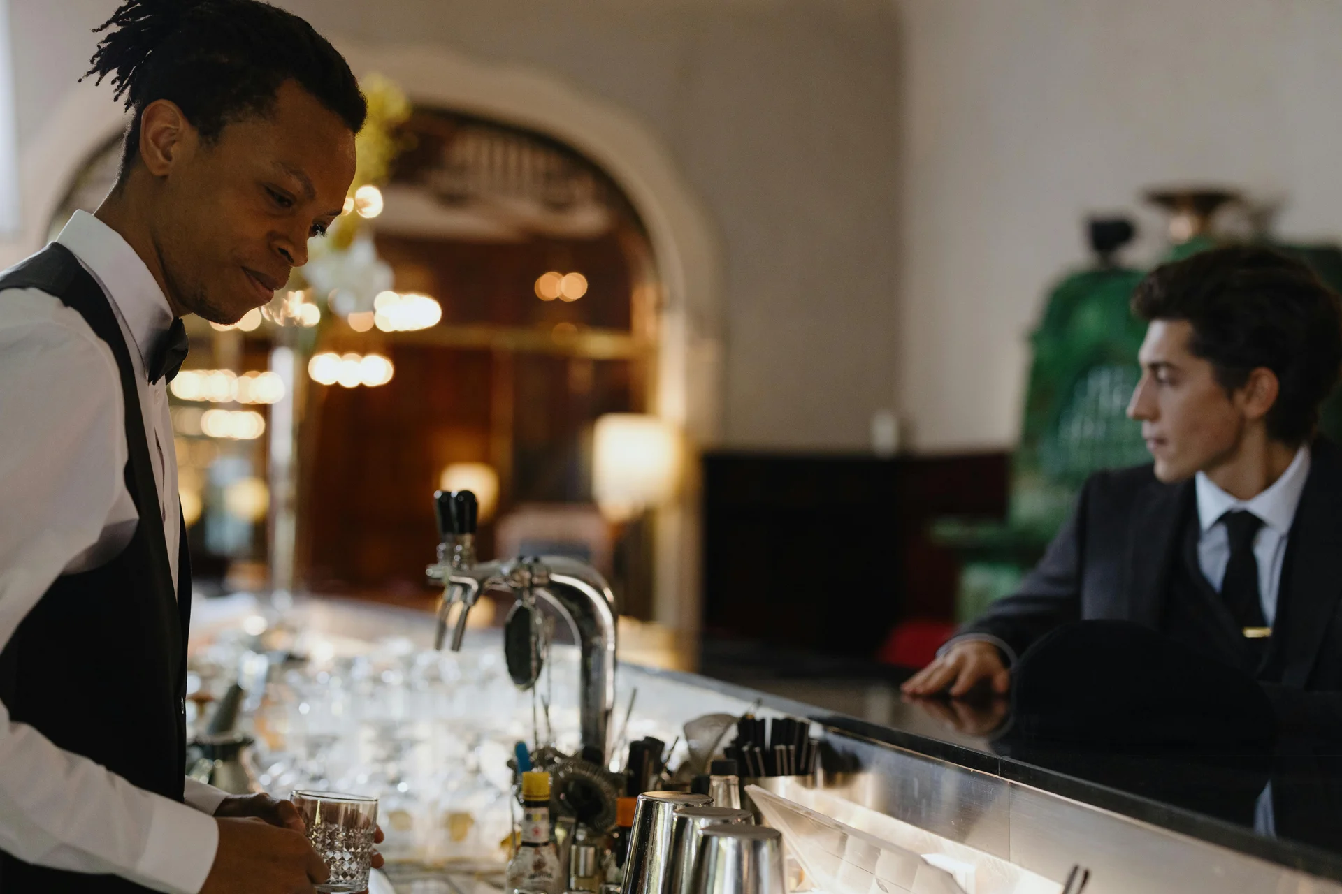 칵테일바에서 바텐더와 고객이 친근하게 대화하는 모습