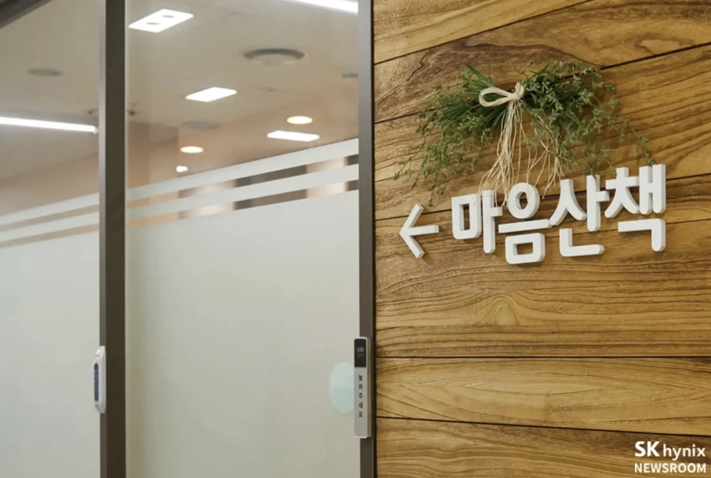 sk하이닉스의 '마음챙김 상담소' 입구. 유리 자동문 옆 나무 벽에 '마음산책'이라는 안내 글씨와 함께 유리문을 가리키는 화살표가 있다.