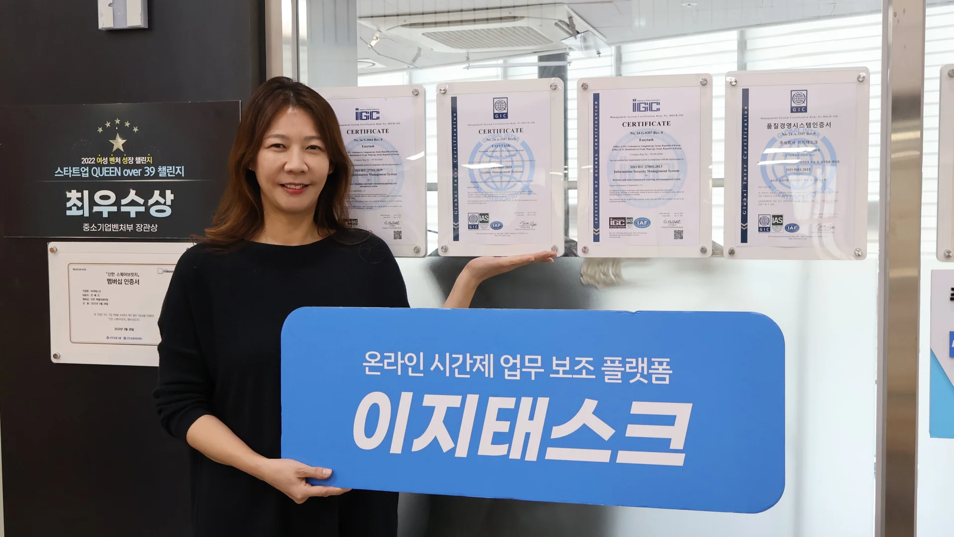 취득한 인증서 앞에 서 있는 이지태스크 전혜진 대표