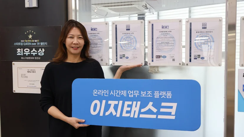 취득한 인증서 앞에 서 있는 이지태스크 전혜진 대표