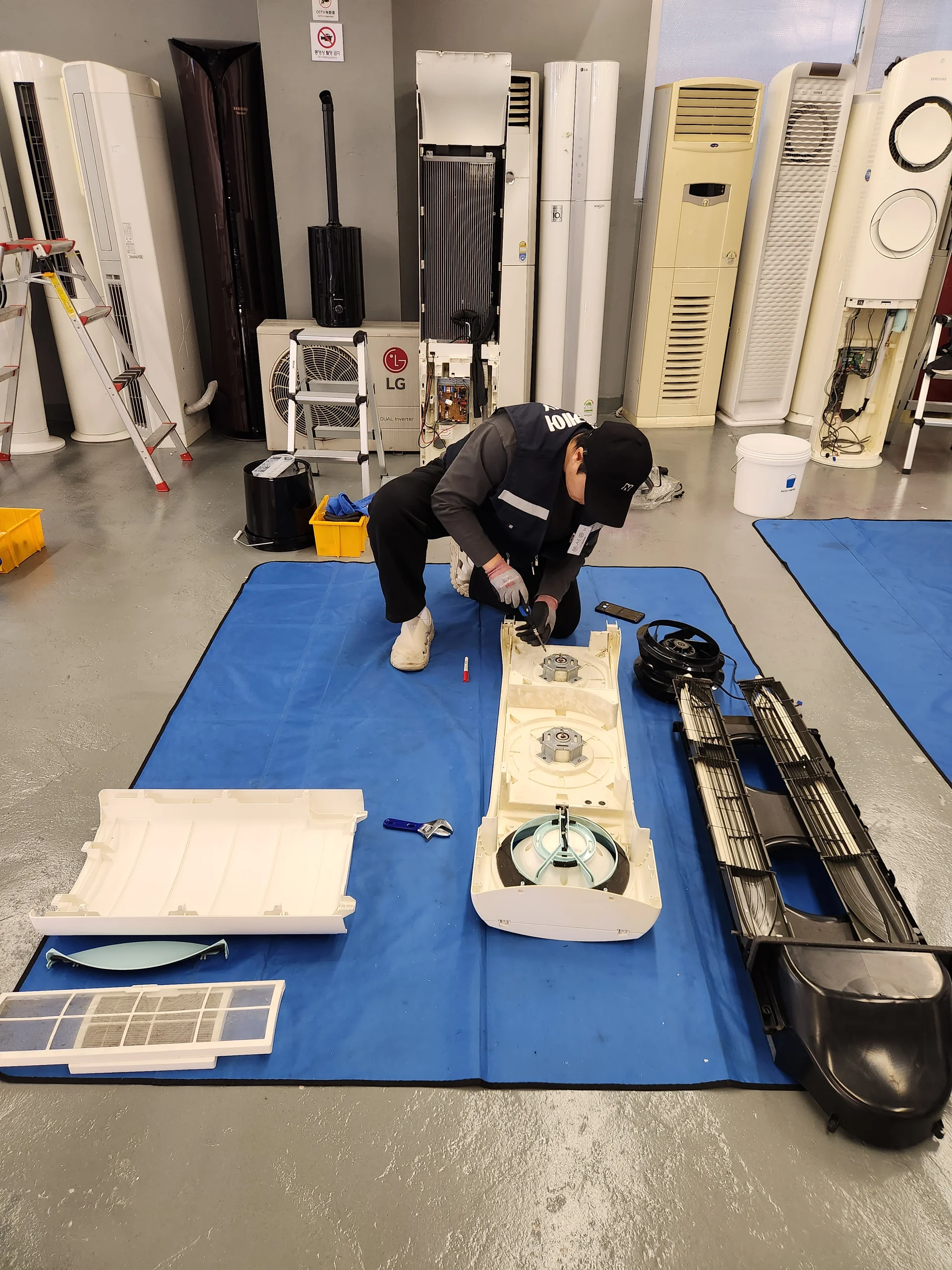 홈케어 전문가가 에어컨을 분해 청소하는 모습