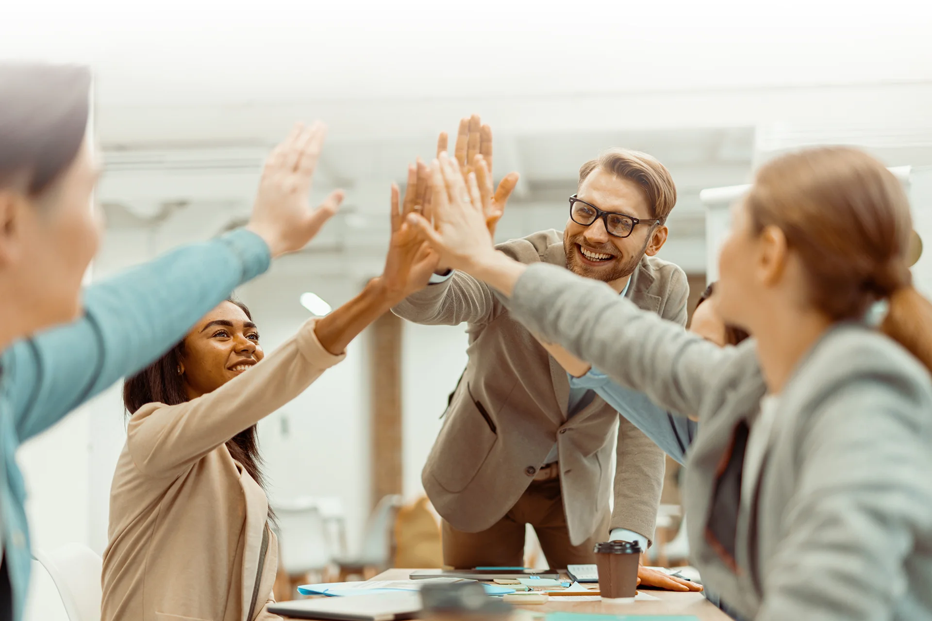 5명의 조직 구성원들이 모여 즐겁게 서로 하이파이브를 하고 있는 모습