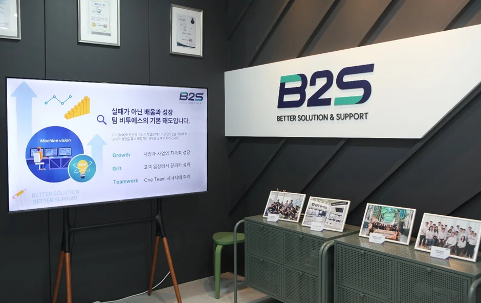 비투에스 회사 내부의 모습으로 임직원의 사진이 놓여 있다.