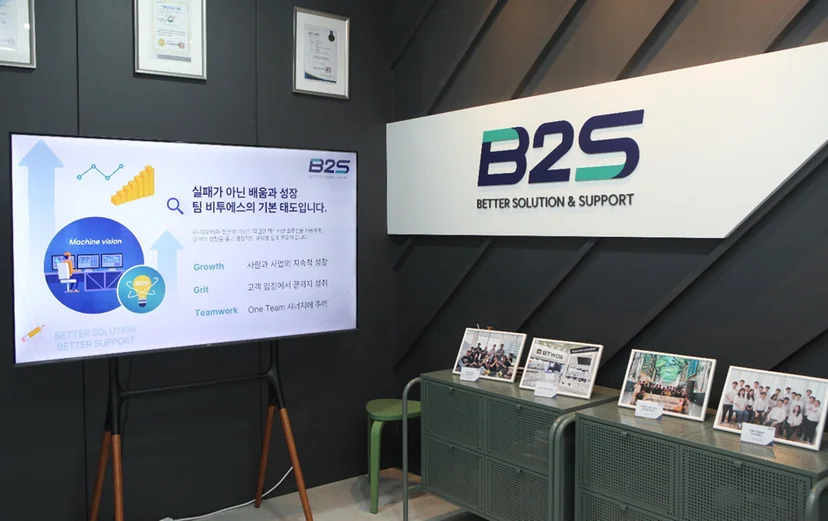 비투에스 회사 내부의 모습으로 임직원의 사진이 놓여 있다.