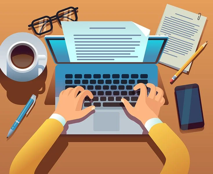 Person writing on laptop at desk with documents