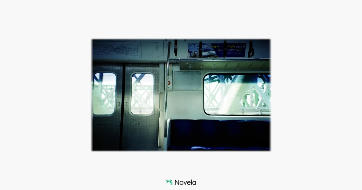 지하철 안에서 촬영된 풍경 사진. 창문 너머로 철교 구조물이 흐릿하게 비쳐 보이며, 텅 빈 파란색 좌석과 열차 문 위로 은은한 빛이 스며든다. 조용하고 고요한 분위기 속에 한적한 일상의 순간이 포착되어 있다. 이미지 아래에는 ‘Novela’ 로고가 작게 배치되어 있으며, 이 카드는 “일상이라는 사소한 순간들 속에 이야기가 숨어 있다”는 주제를 담은 글과 함께 실린다. 글에서는 평범한 하루, 스친 표정, 창밖 풍경, 카페의 대화 조각 등 일상 속 사소한 순간들이 이야기가 되는 가능성을 이야기한다. 또한 “우리는 삶의 사소한 것들 속에서 무한한 아름다움을 발견해야 한다”는 문장을 인용하며, 관찰과 상상을 통해 작가가 되는 감각을 제안한다.