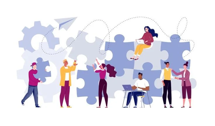 People working on big puzzle pieces as teamwork metaphor