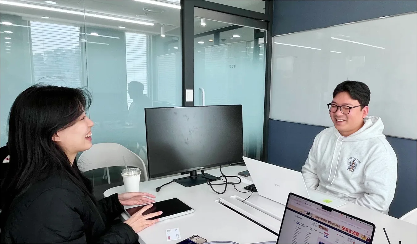 부가세 환급과 구매 정산 흐름에 대해 논의 중인 밀리온 담당자와 인터뷰 장면