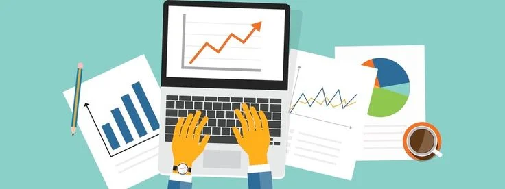 Hands typing on laptop with charts and analytics reports