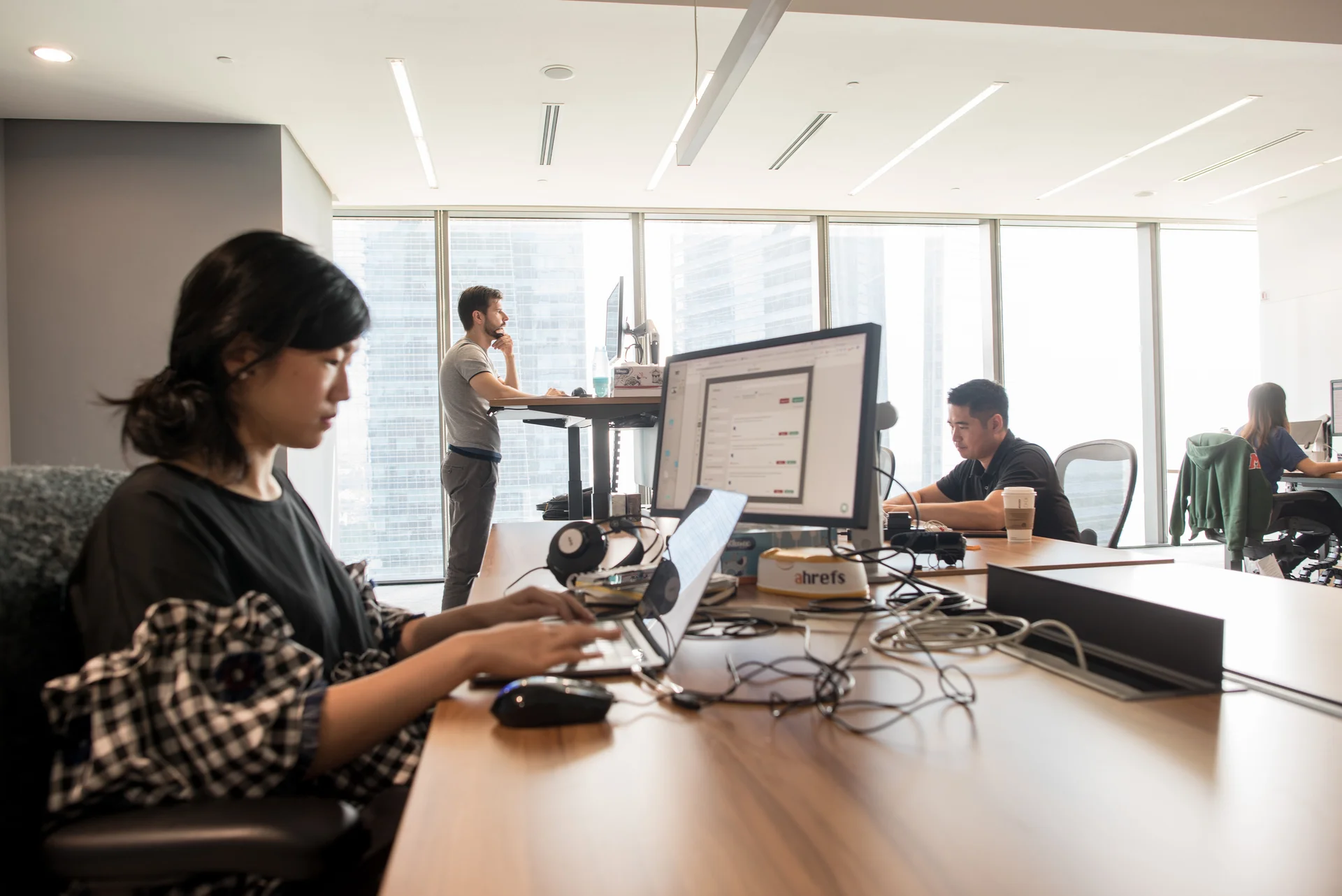 Ahrefs team working in a modern office with laptops and standing desks