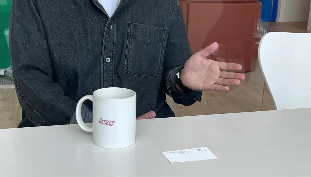 Interview moment with hand gesture and ‘hoxy’ mug, representing operational insight from TBR team