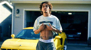 정교하게 꾸며진 인형이 어두운 무대 위 조명 아래에서 천천히 회전한다. 인형은 붉은색 계열의 고전적인 드레스를 입고 있으며, 정면과 측면이 교차로 비춰진다. 인형의 움직임은 마치 살아 있는 듯 부드럽고, 조명의 반사로 인형의 표정과 옷 디테일이 선명하게 드러난다.