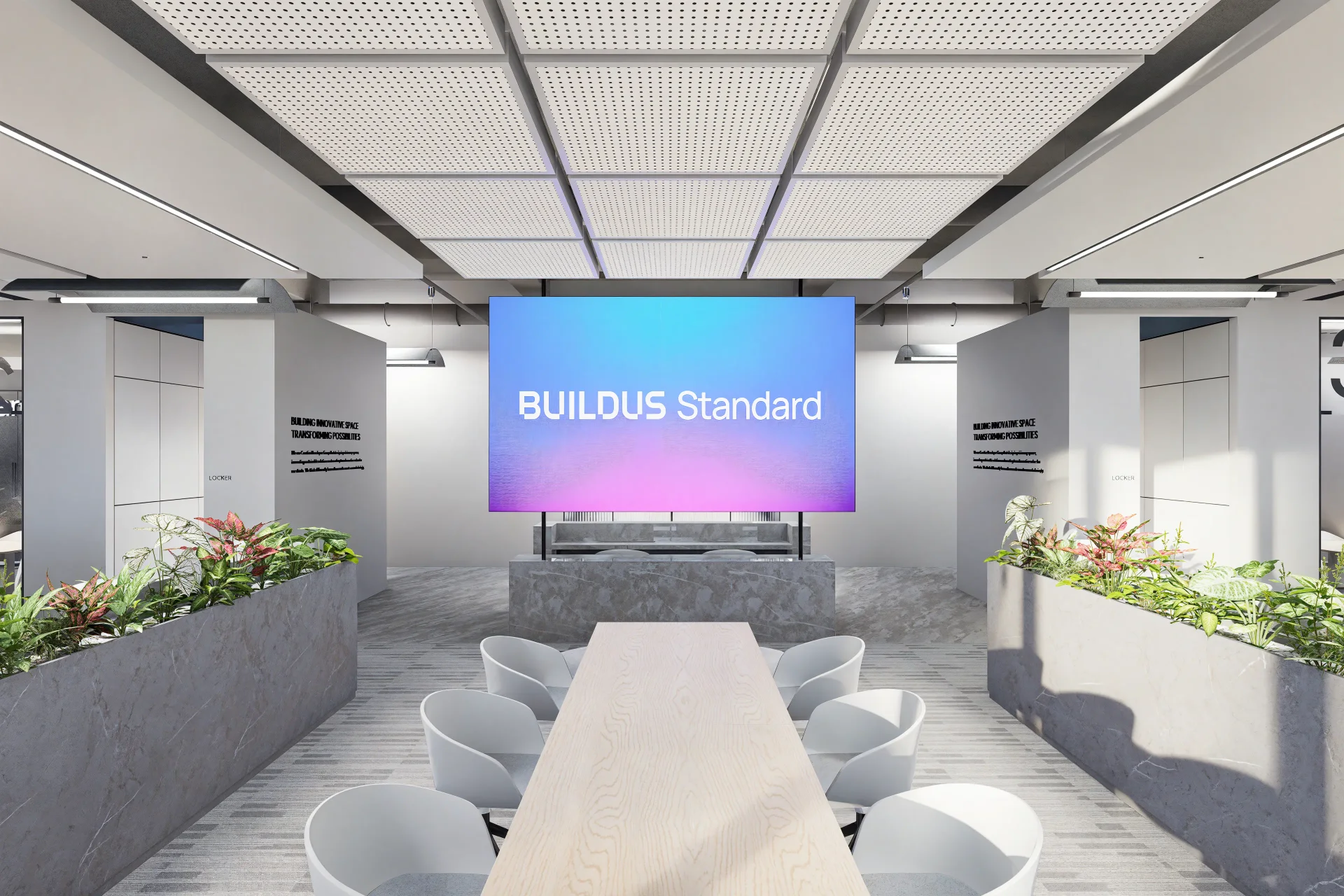 BUILDUS Standard 로고가 표시된 대형 스크린이 설치된 현대적인 회의실. 천장에는 격자형 음향 패널이 있고, 중앙에는 긴 원목 테이블과 회색 의자들이 배치되어 있으며, 양쪽에는 식물이 있는 콘크리트 화분이 놓여있다.