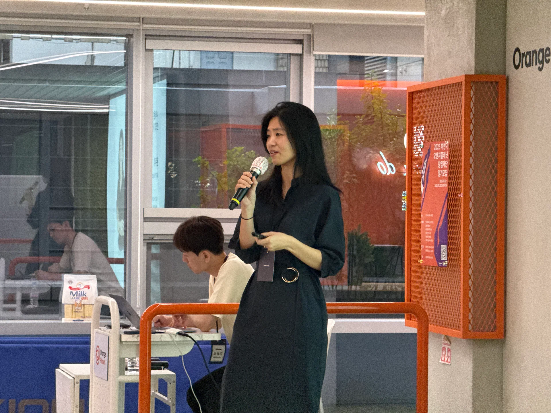 40FY 문우리 CEO가 단상에서 마이크를 잡고 강연을 진행 중이다.