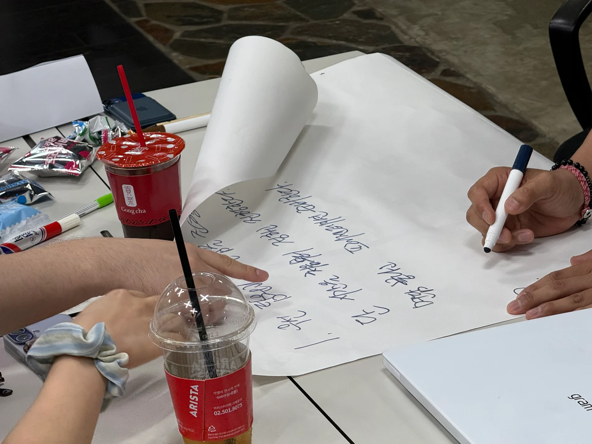 스푼랩스 리더십 워크샵에 참여한 리더들이 액티비티를 진행하며 전지 위에 마카로 토의 내용을 적고 있다.