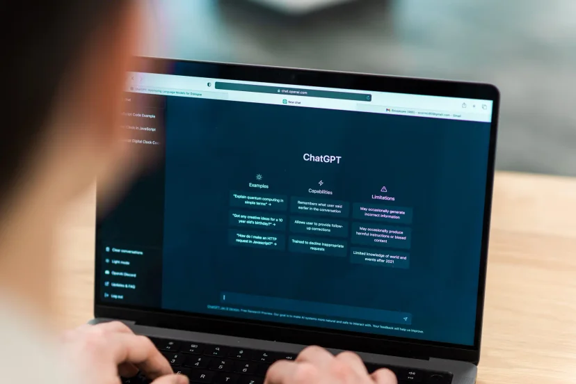 A user interacting with ChatGPT on a laptop—an example of how AI can naturally draw out context and tacit knowledge through conversation-driven UX.