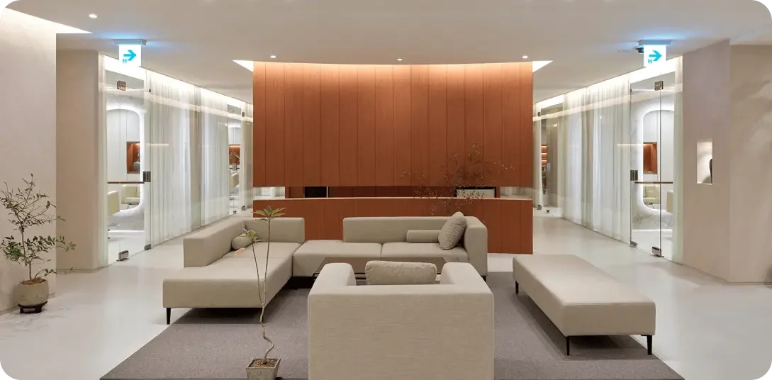 공유미용실 아데르 라운지 공간 전경, 미니멀한 소파와 우드톤 인테리어