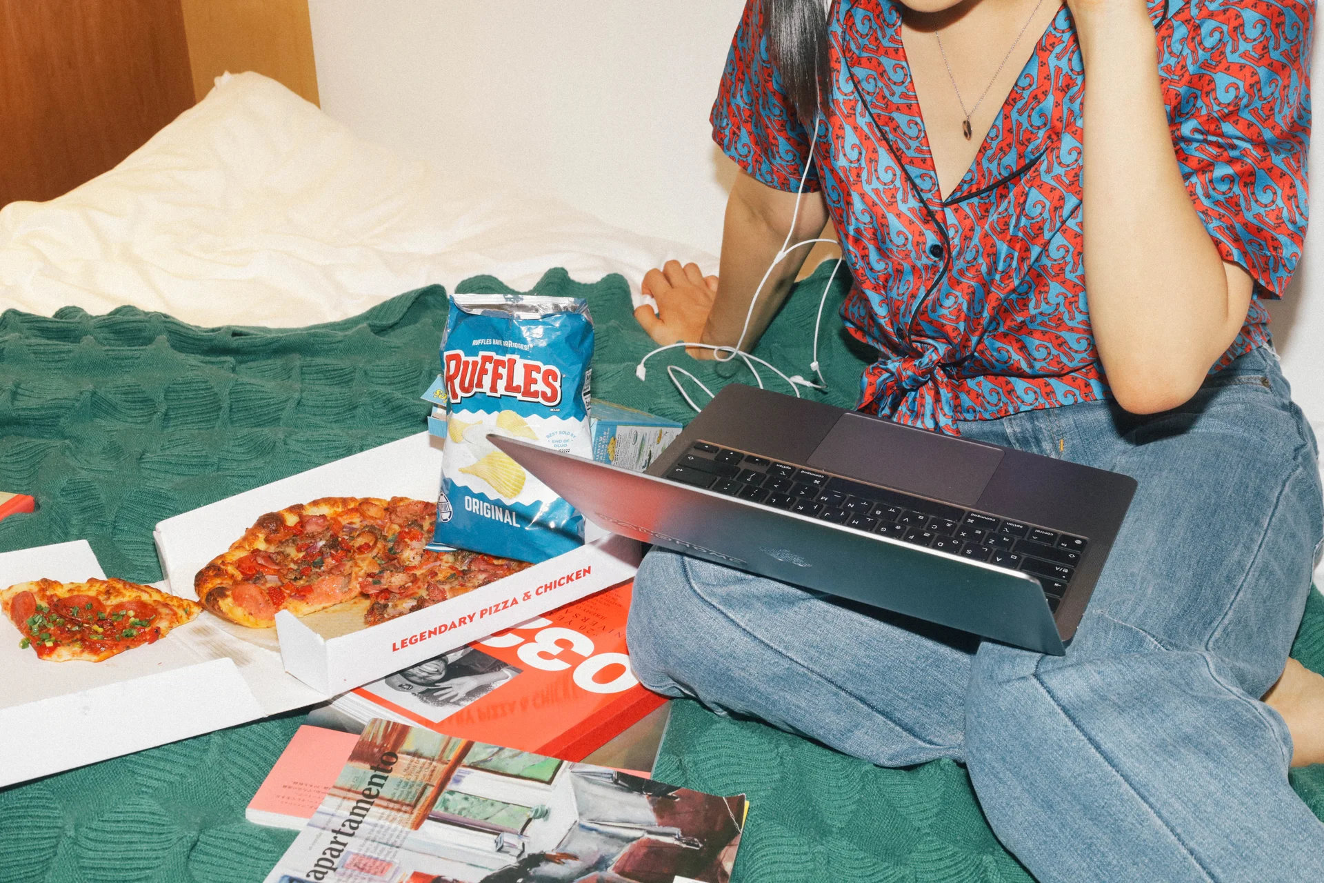 서울 맹그로브 신설 싱글룸 개인 공간. 입주민이 침대 위에서 노트북을 사용하며 피자와 스낵을 즐기는 모습으로, 장기 숙박과 1인 생활에 최적화된 프라이빗한 객실 환경을 보여준다. 편안한 침대와 여유로운 분위기 속에서 휴식, 업무, 여가를 모두 누릴 수 있는 코리빙 하우스 개인 공간.