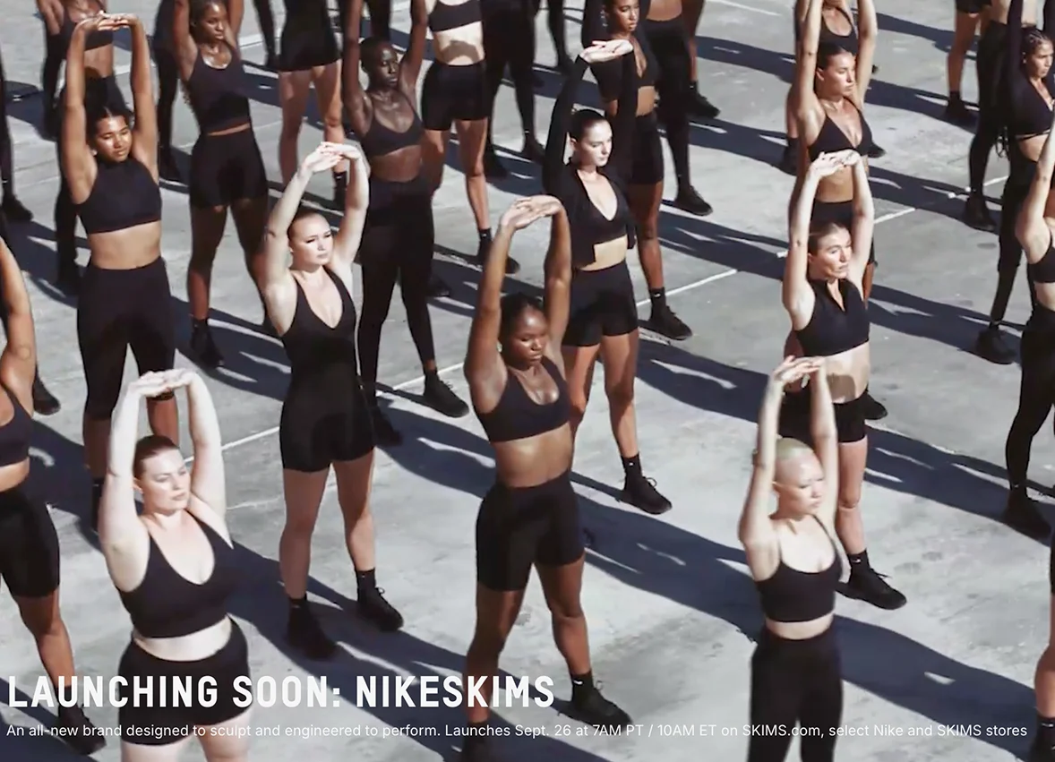 나이키와 스킴스(Nike x SKIMS) 협업 캠페인 – 다양한 인종과 체형의 모델들이 블랙 스포츠웨어를 입고 단체로 스트레칭하는 장면