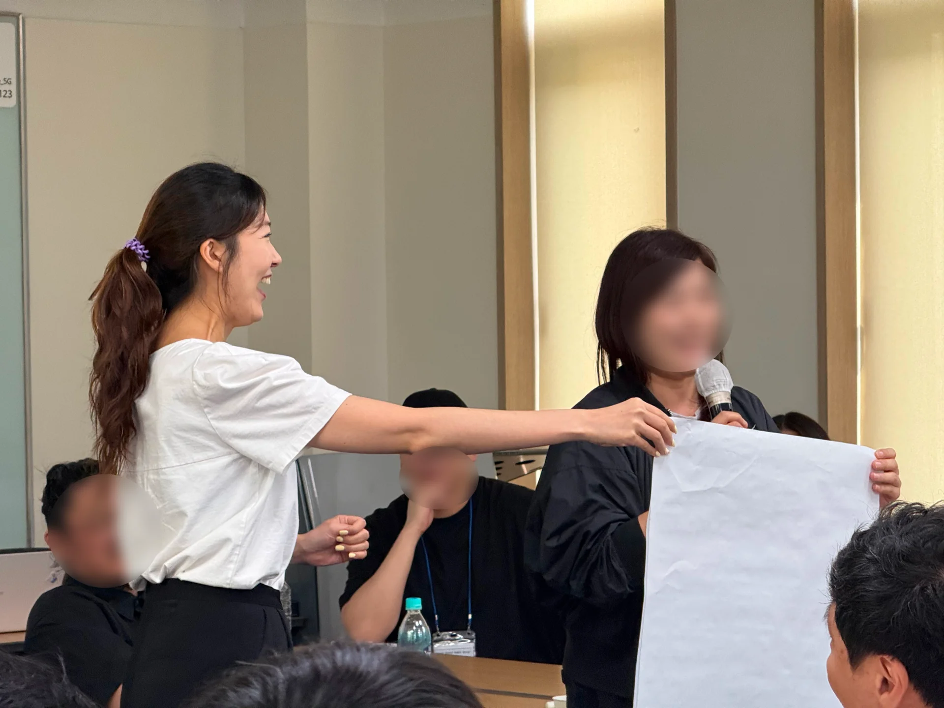 업피플 황인애 코치와 아이코닉스 리더십 교육에 참여한 리더 한 명이 나란히 서서, 전지에 적힌 조별 토의 결과를 발표하고 있다.