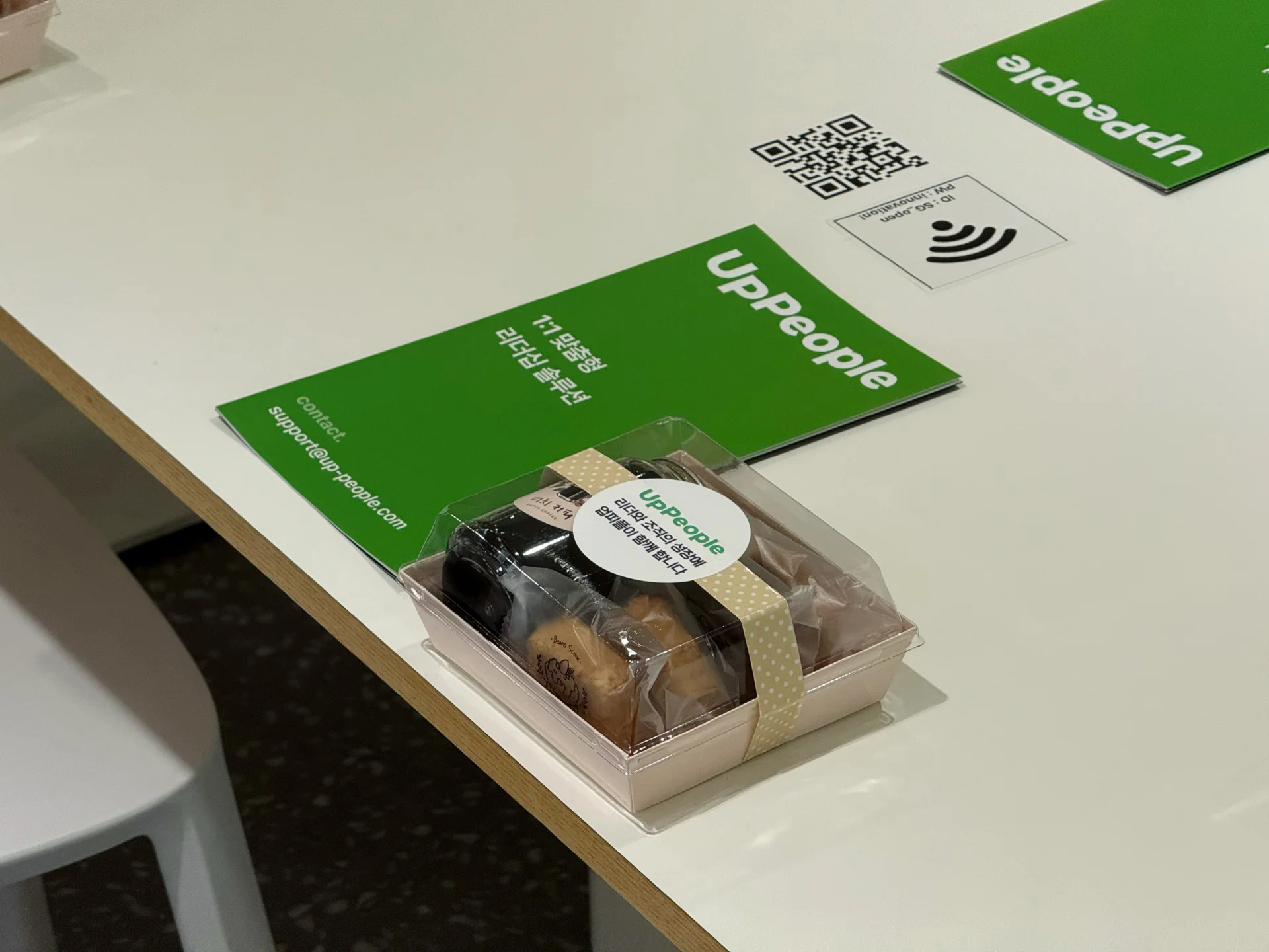 세미나 시작 전, 책상 위에 참석자들이 받아볼 업피플 팜플렛과 간단한 다과가 올려져있다.