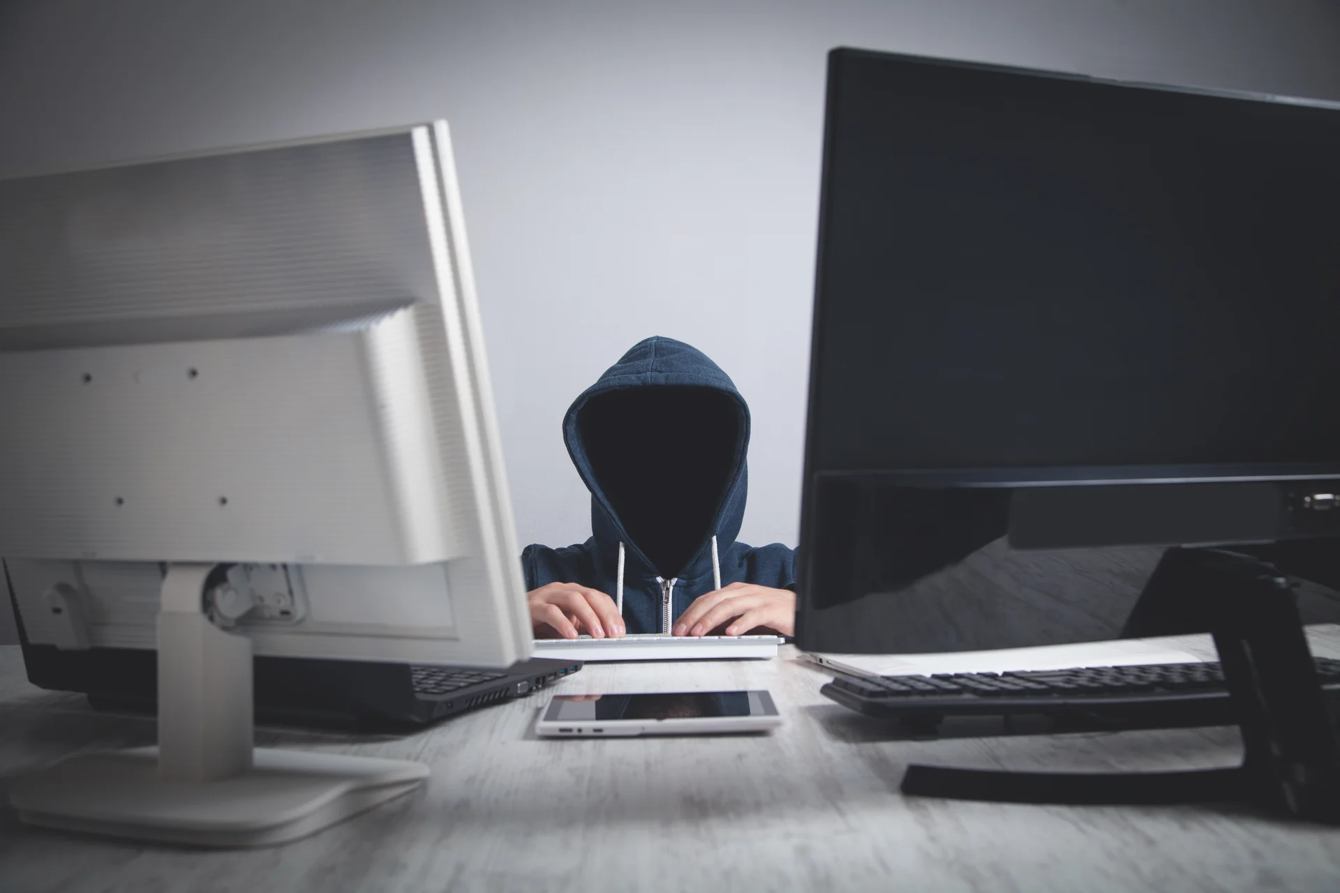 A man sitting at a desk hacking into a computer