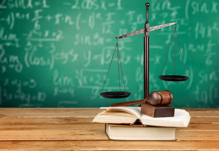 책상 위에 저울, 의사봉, 책이 놓여 있는 이미지로 법정의무교육을 상징