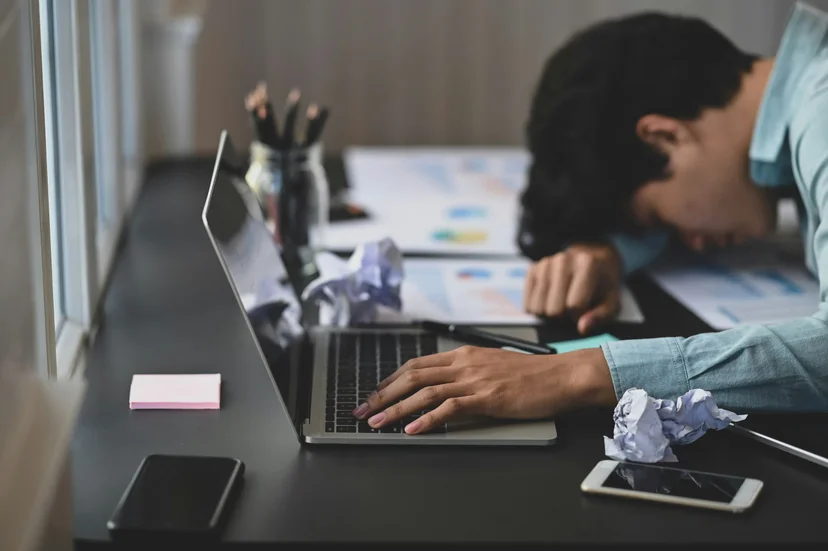 일하다가 엎드려 자고 있는 남자의 모습. 성인 ADHD 환자가 지루한 과제를 수행할 때 겪는 졸음 현상을 표현한 이미지.