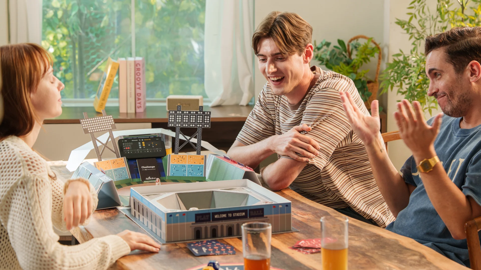 3명의 플레이어가 베이스 온 보드 게임을 함께 즐기고 있는 모습