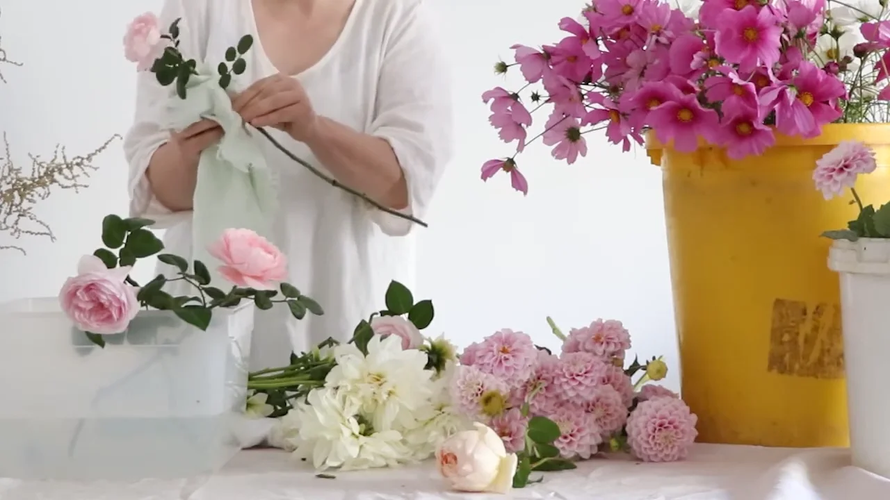 작업대 위에서 꽃을 손질하고 정리하는 플로리스트의 모습