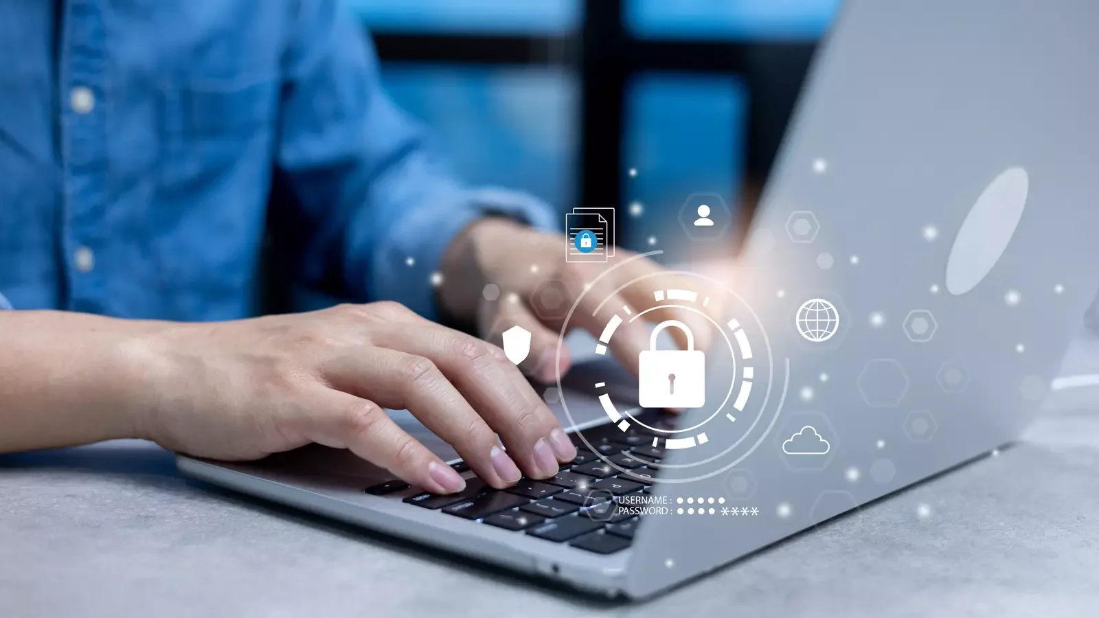 노트북에서 타이핑하는 손과 보안 자물쇠 아이콘, 사용자 아이디와 비밀번호 입력란이 그래픽으로 오버레이된 모습