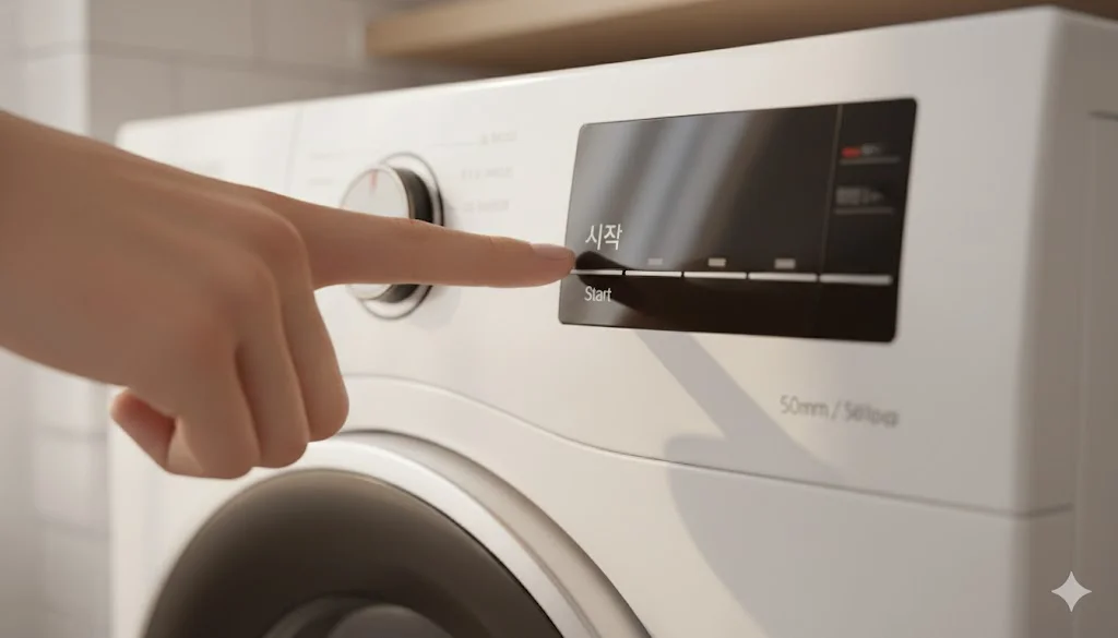 Close-up of finger pressing start on Korean washer.