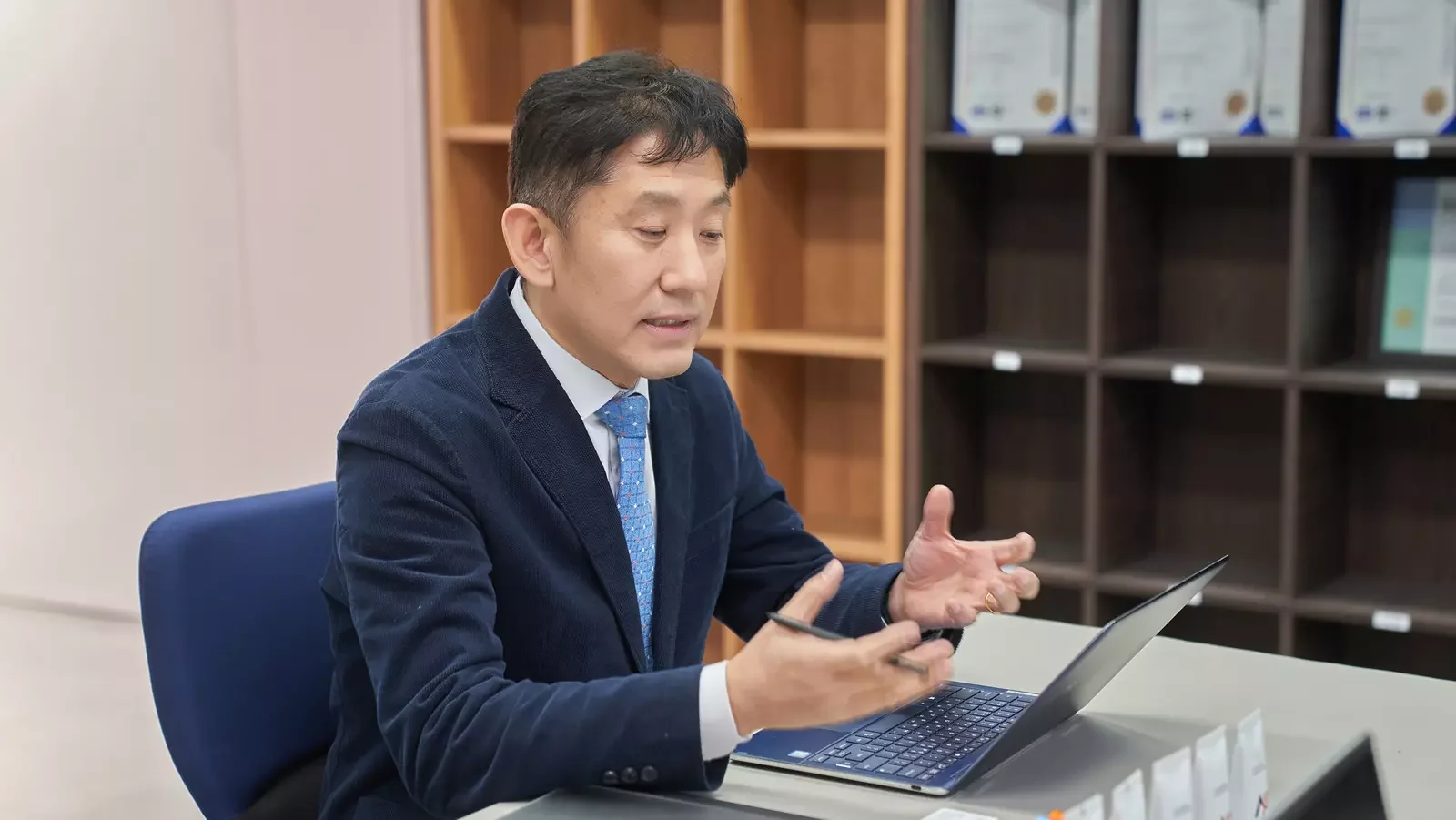 노트북 앞에서 설명하는 손짓을 하는 남자