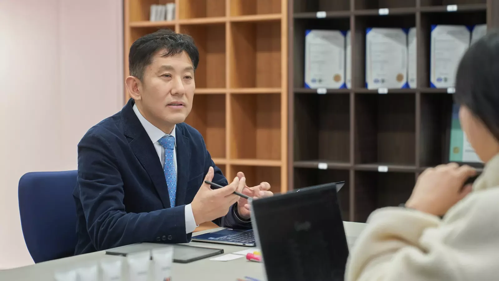 여성 인터뷰어 앞에서 무언가를 설명하는 남자