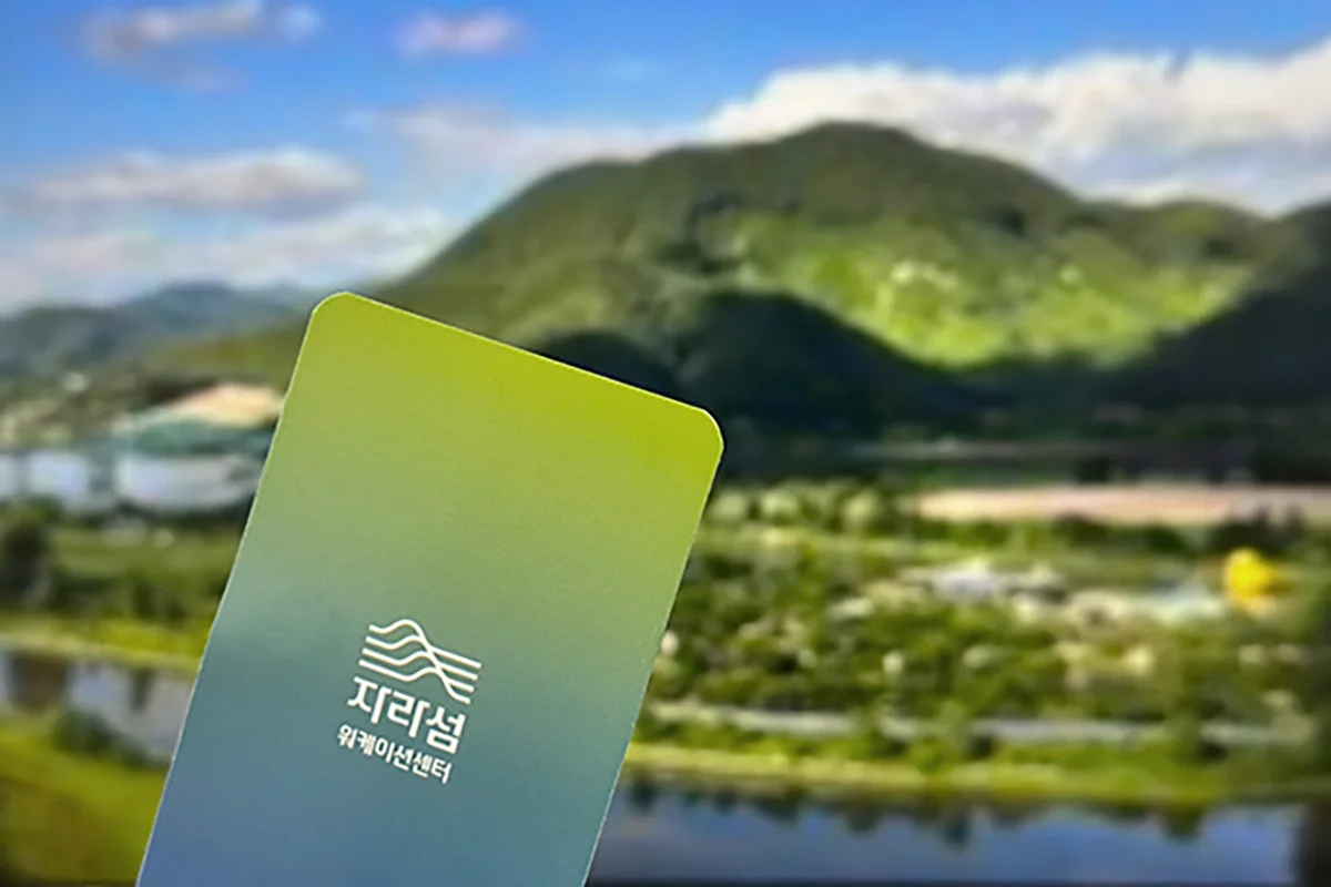 가평 자라섬 워케이션 센터 전경을 배경으로 한 디어먼데이 워케이션 이용권과 바우처 카드