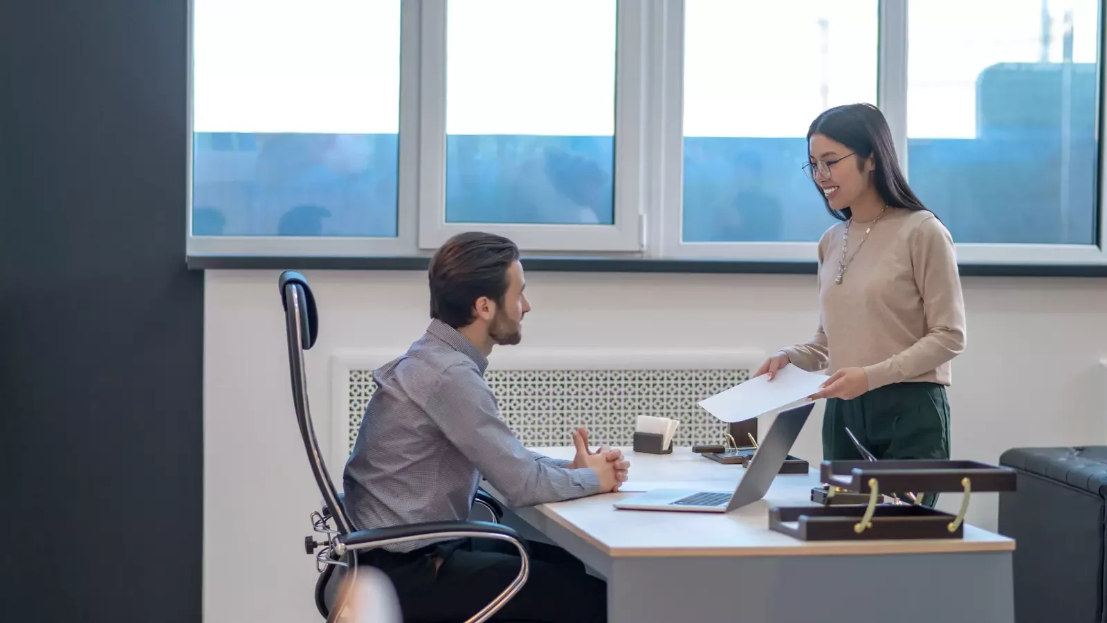 사무실 내 회의실에서 직원들이 퇴직급여 및 퇴직연금 계획에 대해 대화하며 관련 서류를 주고받는 모습, 실제 업무에서의 퇴직급여 충당금 관리 절차를 나타낸 장면