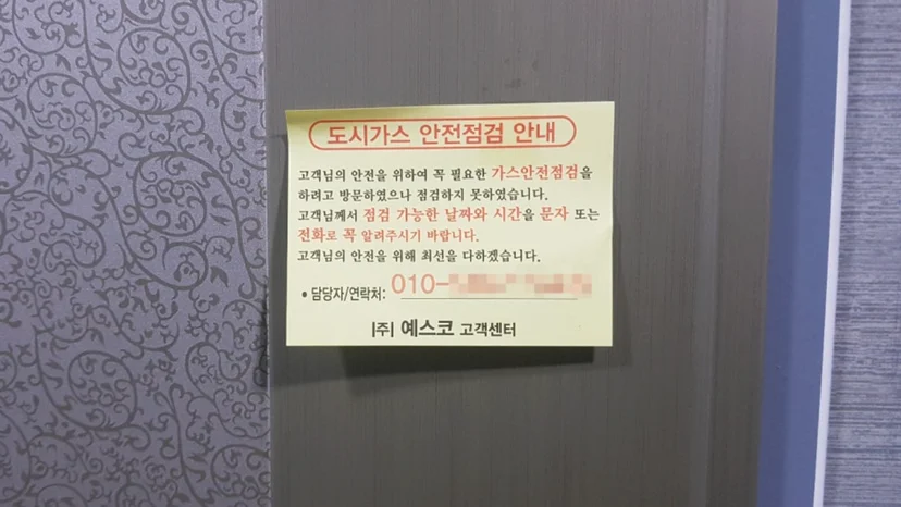 Yellow gas inspection notice on a studio door.