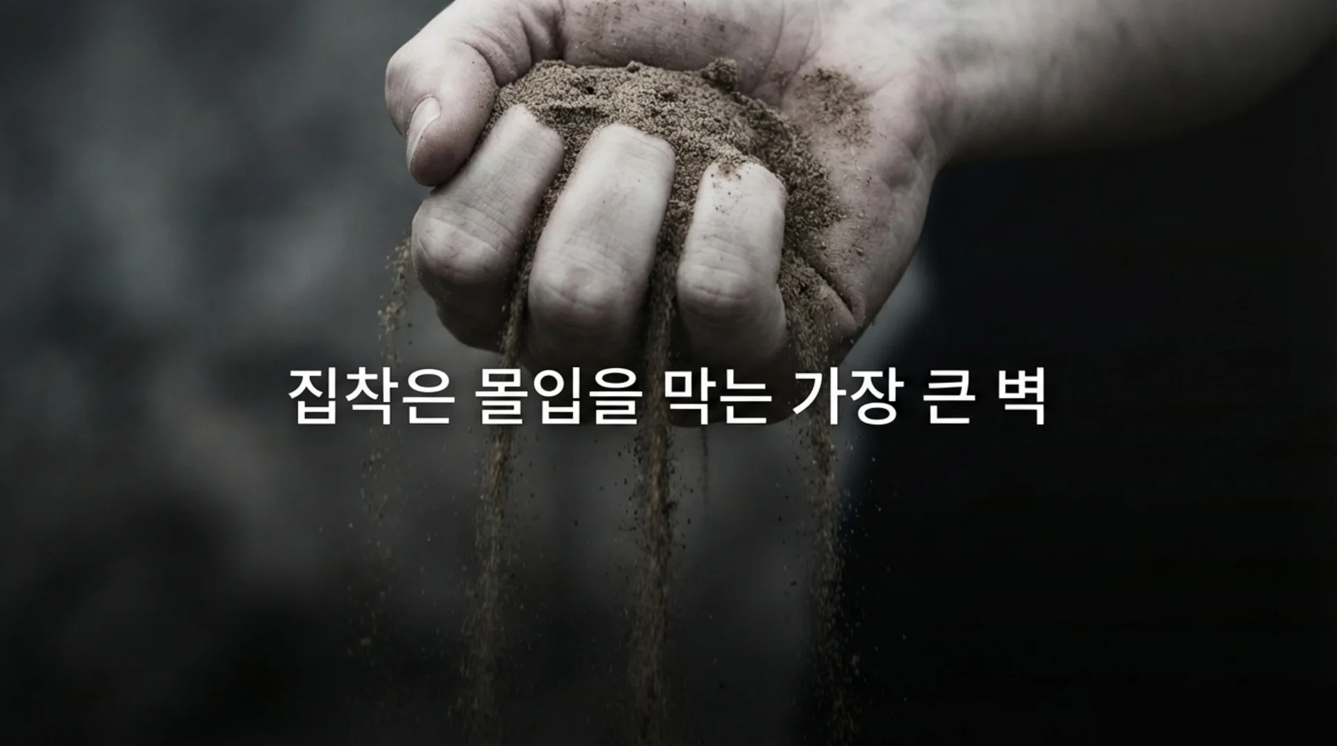 어두운 배경에서 손에 모래 한 줌을 쥐자 손가락 사이로 모래알이 흘러내리는 흑백 계열의 클로즈업 사진