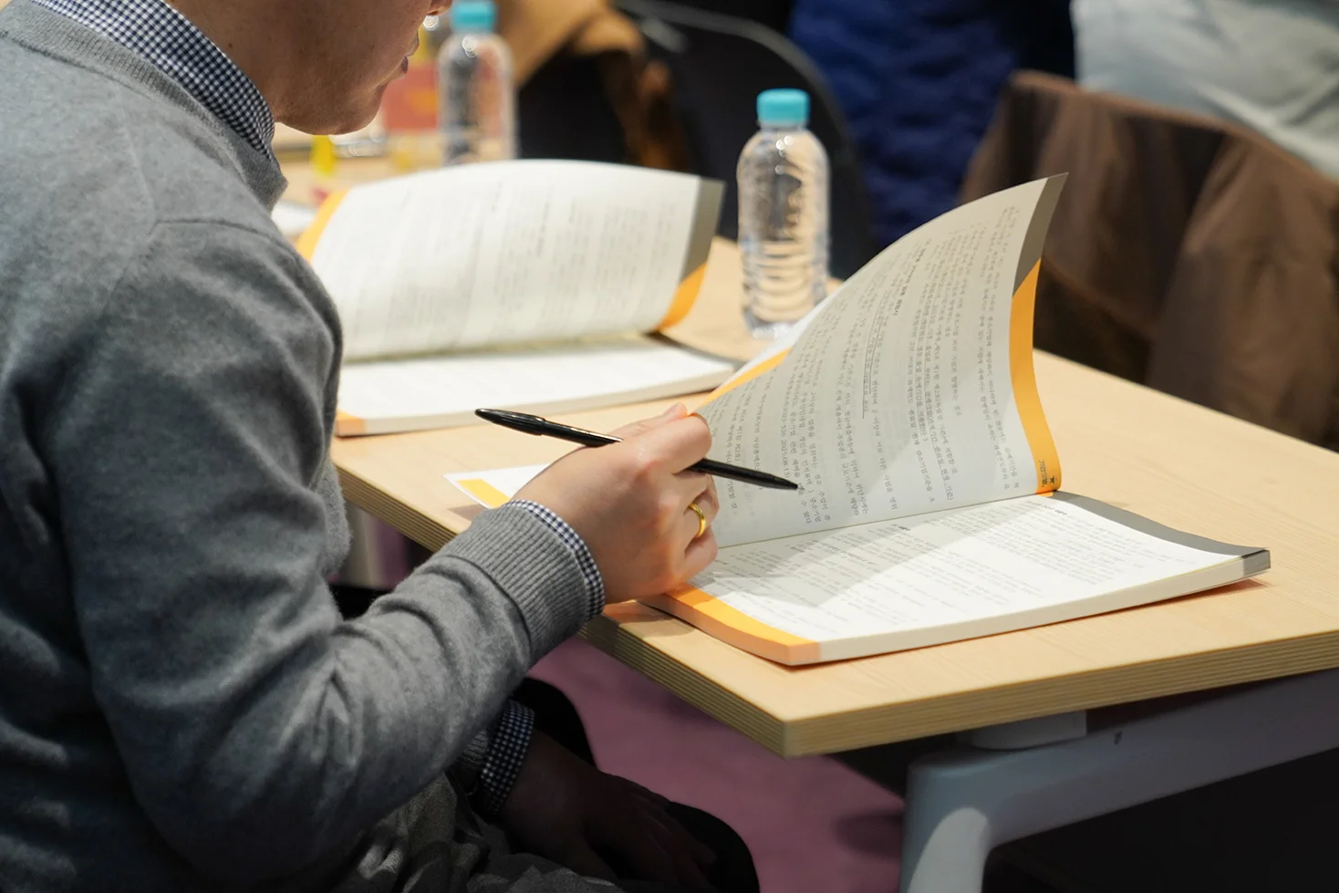 남성세무사가 책상에 앉아 교재를 넘기는 모습