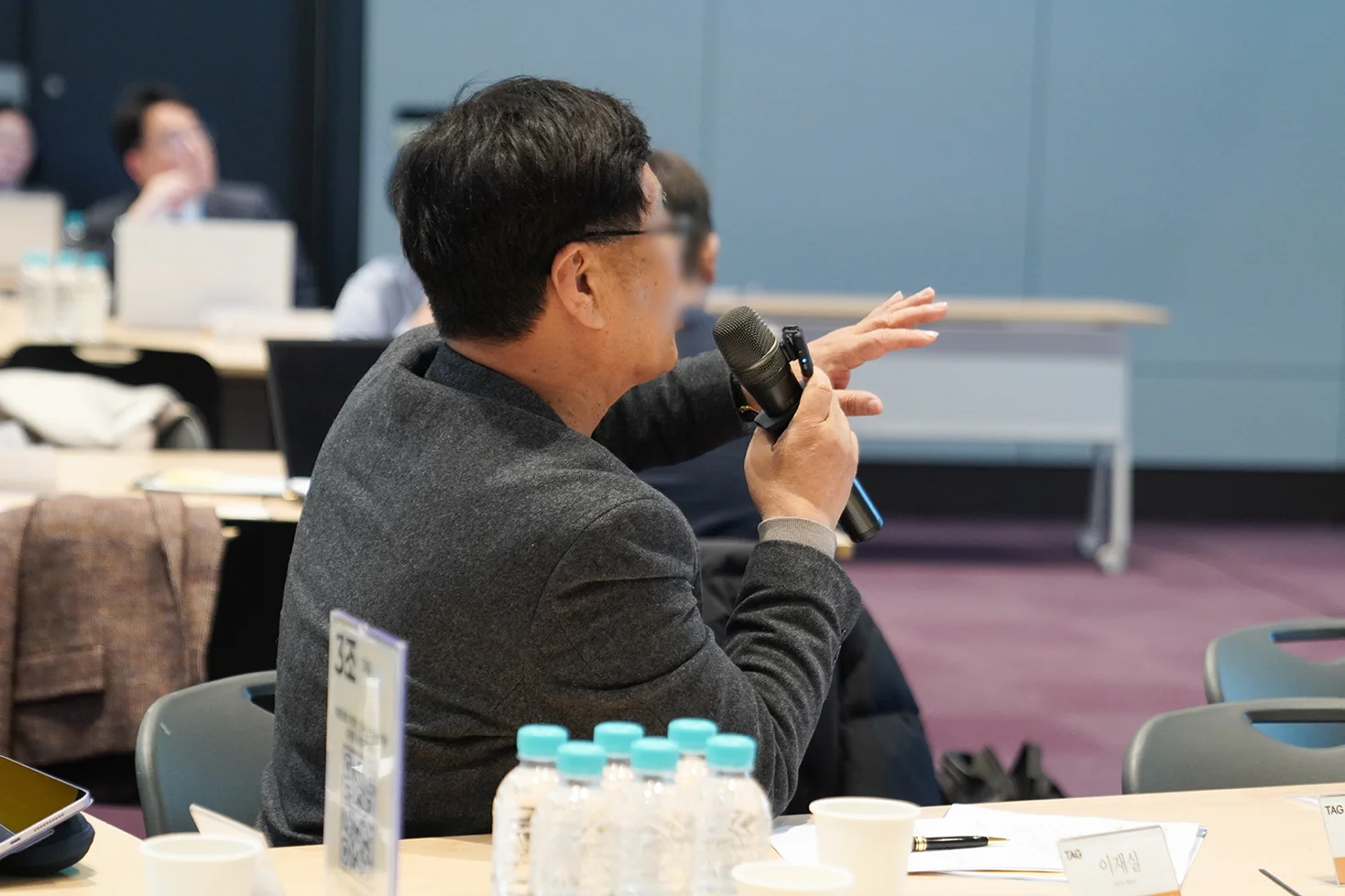 중년의 남성세무사가 마이크를 들고 질문하는 사진