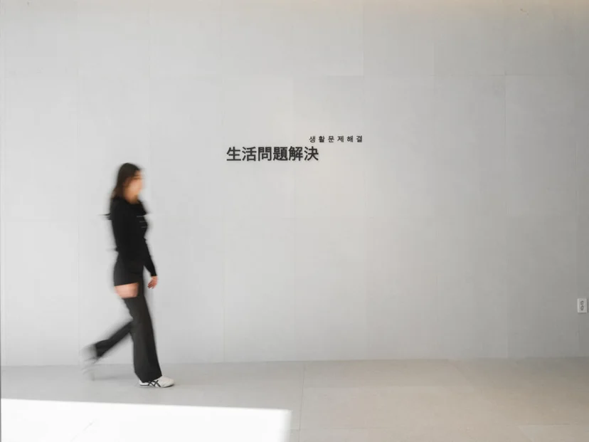 앳홈 오피스 흰 벽면에 새겨진 生活問題解決(생활문제해결) 문구 앞을 걷는 직원