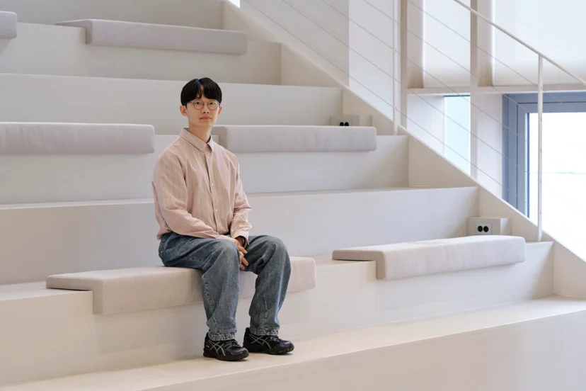 앳홈 SCM 팀원이 오피스 계단식 좌석에 앉아 포즈를 취한 모습