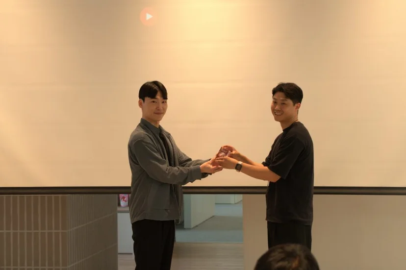 피플 오브 앳홈 시상식에서 두 직원이 트로피를 함께 들고 있는 모습