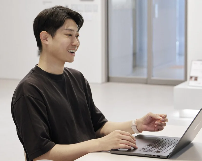 앳홈 팀원이 밝은 공간에서 노트북을 타이핑하며 웃는 모습