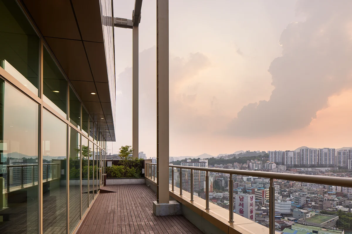 Mangrove rooftop terrace with panoramic Seoul skyline view at sunset — an exclusive outdoor space for residents to relax, socialize, or decompress after class.