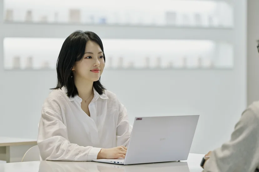 앳홈 마케팅 팀원이 밝은 회의실에서 노트북을 앞에 두고 인터뷰에 응하는 모습