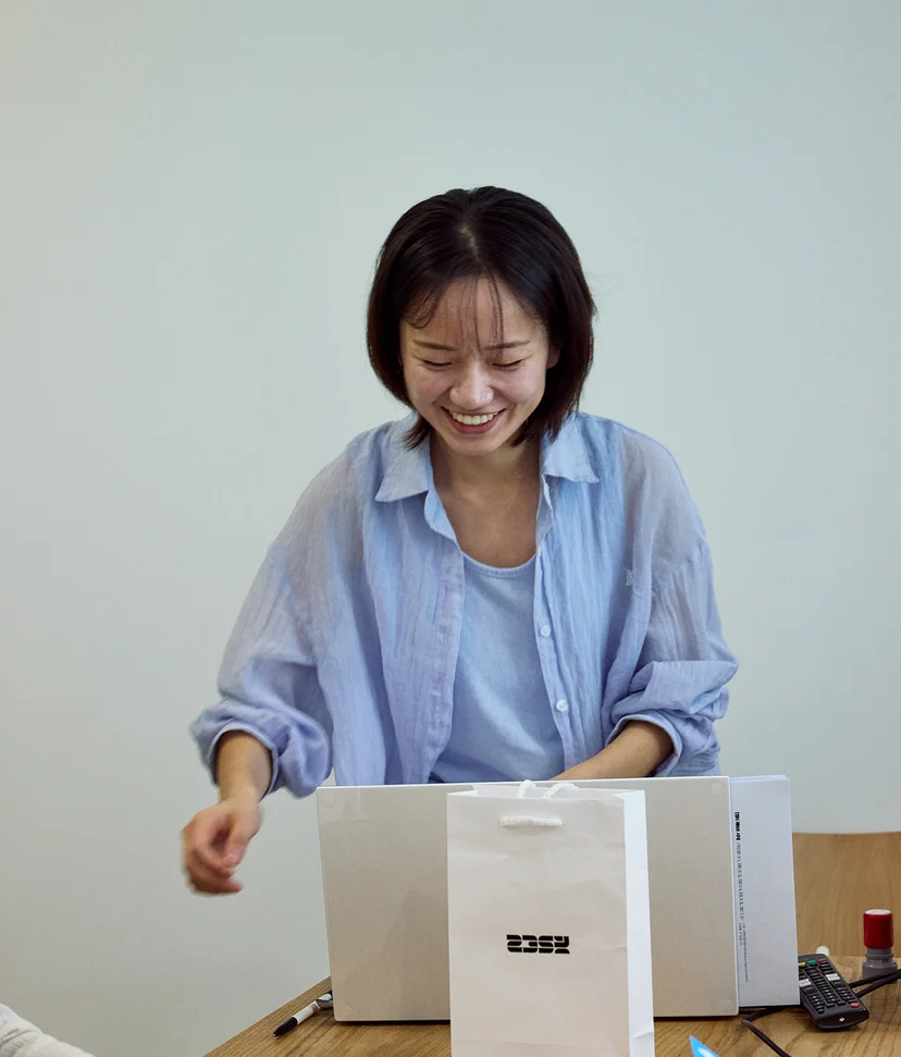 2359 임정아 팀장님이 책상 앞에서 환하게 웃고 있다.